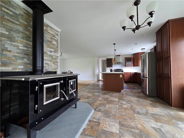 4197 County Highway 26, Colchester, NY 13782 - kitchen with freestanding refrigerator, wall chimney range hood, a wood stove, a center island, and light stone finish flooring