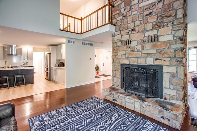 47 Stonington Dr, Pittsford, NY 14534 - living area featuring a towering ceiling, light wood-type flooring, and a stone fireplace