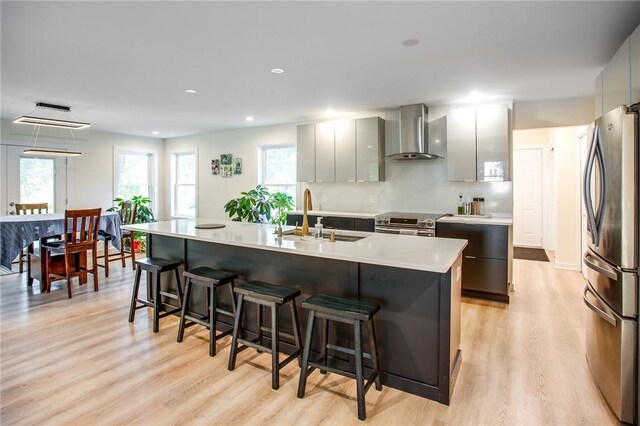 47 Stonington Dr, Pittsford, NY 14534 - kitchen with wall chimney range hood, stainless steel appliances, a center island with sink, modern cabinets, and recessed lighting