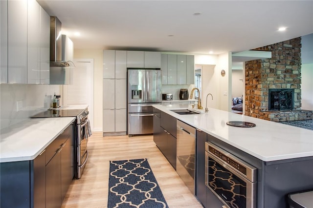 47 Stonington Dr, Pittsford, NY 14534 - kitchen with appliances with stainless steel finishes, wall chimney exhaust hood, modern cabinets, light wood finished floors, and light countertops