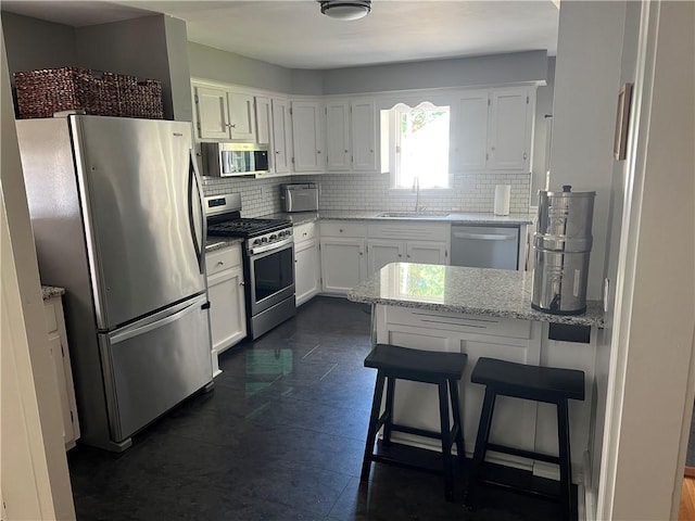 78 Falleson Rd, Rochester, NY 14612 - kitchen with stainless steel appliances, tasteful backsplash, white cabinetry, and light stone counters