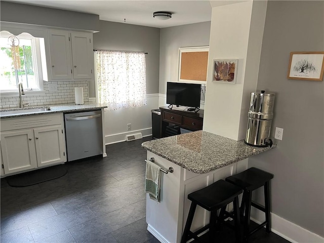 78 Falleson Rd, Rochester, NY 14612 - kitchen featuring dishwasher, a peninsula, light stone counters, and backsplash