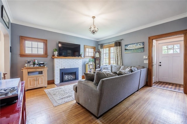 142 Holloway Rd, Brighton, NY 14610 - living room featuring plenty of natural light, light wood-style flooring, crown molding, a fireplace, and a chandelier