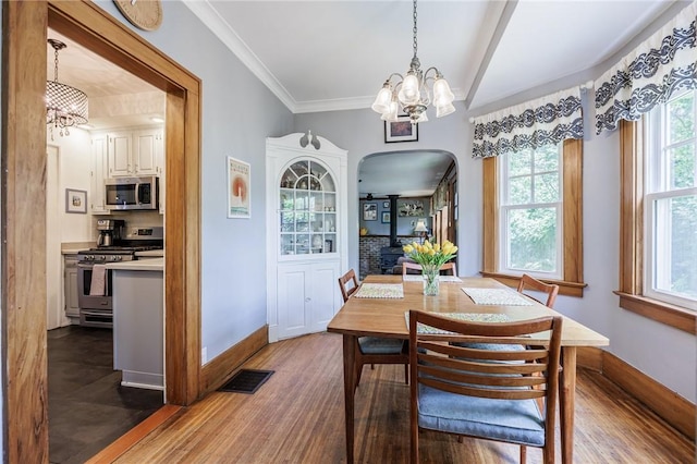 142 Holloway Rd, Brighton, NY 14610 - dining room with arched walkways, a chandelier, dark wood-type flooring, and ornamental molding