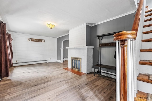 39 Colonial Ave, Lancaster, NY 14086 - unfurnished living room featuring baseboard heating, ornamental molding, wood finished floors, stairs, and a fireplace