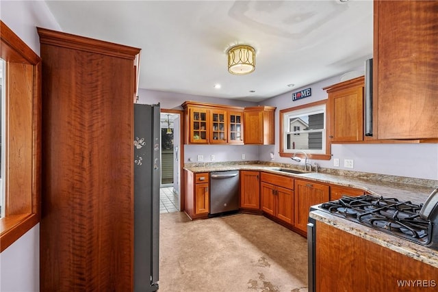 39 Colonial Ave, Lancaster, NY 14086 - kitchen with stainless steel dishwasher, brown cabinets, gas range, and light carpet