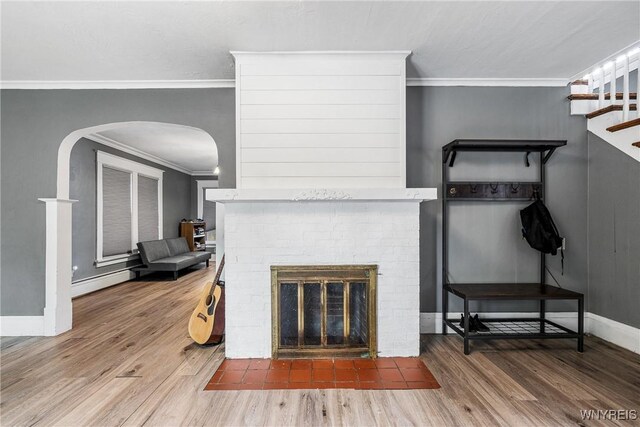 39 Colonial Ave, Lancaster, NY 14086 - living room with arched walkways, crown molding, a fireplace, wood finished floors, and stairway