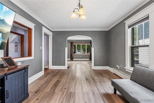 39 Colonial Ave, Lancaster, NY 14086 - living area with arched walkways, a baseboard heating unit, a chandelier, wood finished floors, and crown molding