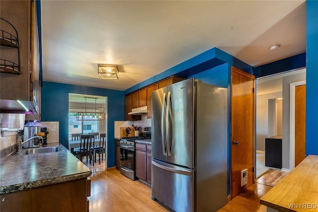 21 Niagara Cir, North Tonawanda, NY 14120 - kitchen featuring stainless steel appliances, under cabinet range hood, dark countertops, light wood-style floors, and tasteful backsplash