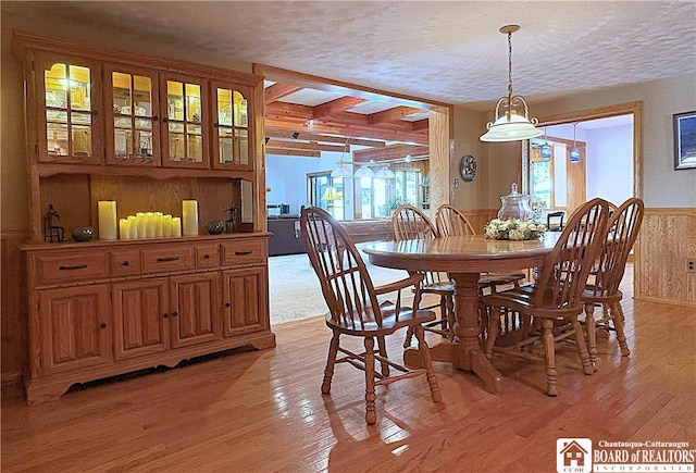 24 W 2nd St, Westfield, NY 14787 - dining space with wood walls, a textured ceiling, light wood-type flooring, a wainscoted wall, and beam ceiling