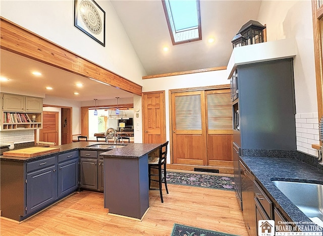 24 W 2nd St, Westfield, NY 14787 - kitchen with a skylight, a breakfast bar, backsplash, light wood finished floors, and recessed lighting