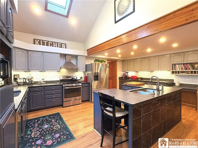 24 W 2nd St, Westfield, NY 14787 - kitchen with stainless steel appliances, wall chimney exhaust hood, backsplash, an island with sink, and high vaulted ceiling