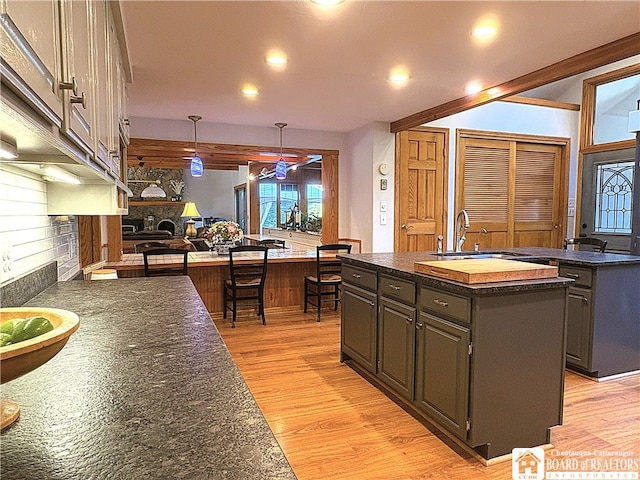 24 W 2nd St, Westfield, NY 14787 - kitchen with a kitchen island with sink, a stone fireplace, light wood-style flooring, recessed lighting, and a ceiling fan