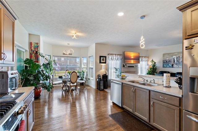37 Etherington Cres, Chili, NY 14428 - kitchen featuring appliances with stainless steel finishes, light countertops, dark wood-style floors, hanging light fixtures, and a chandelier