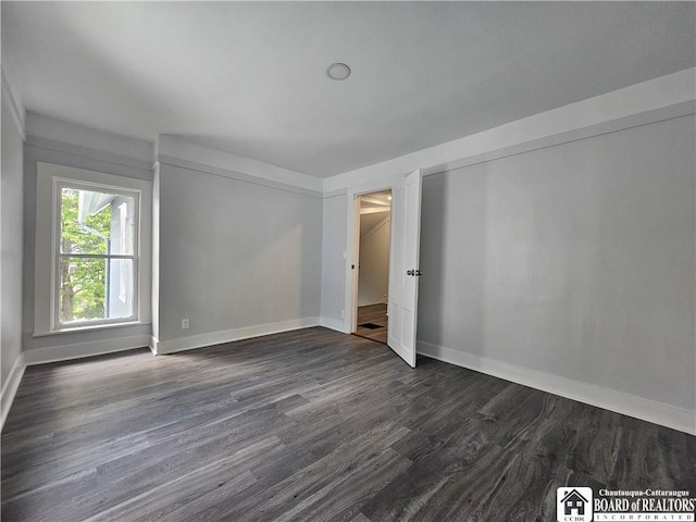 901 W Henley St, Olean, NY 14760 - spare room featuring baseboards and dark wood-style floors