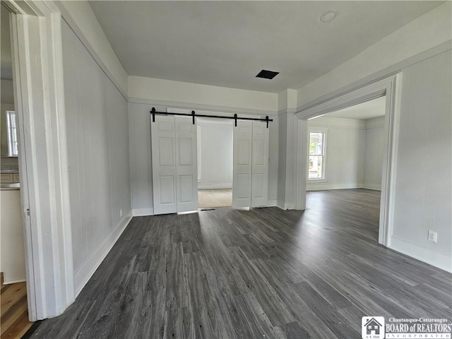 901 W Henley St, Olean, NY 14760 - unfurnished bedroom with a barn door and dark wood-type flooring