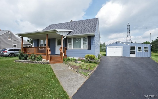 6167 N Whitham Dr, Niagara, NY 14304 - bungalow featuring covered porch, a detached garage, a front yard, an outbuilding, and roof with shingles