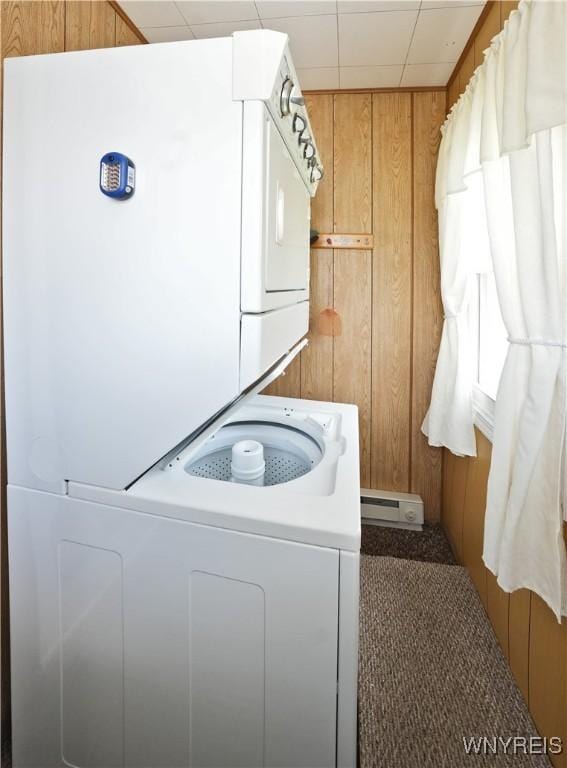 6167 N Whitham Dr, Niagara, NY 14304 - laundry area with estacked washer and dryer, wood walls, a baseboard radiator, and carpet flooring