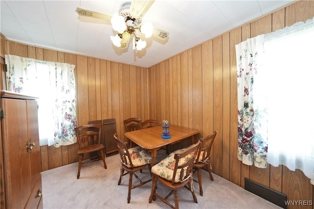 6167 N Whitham Dr, Niagara, NY 14304 - dining area with a ceiling fan, light colored carpet, and wood walls