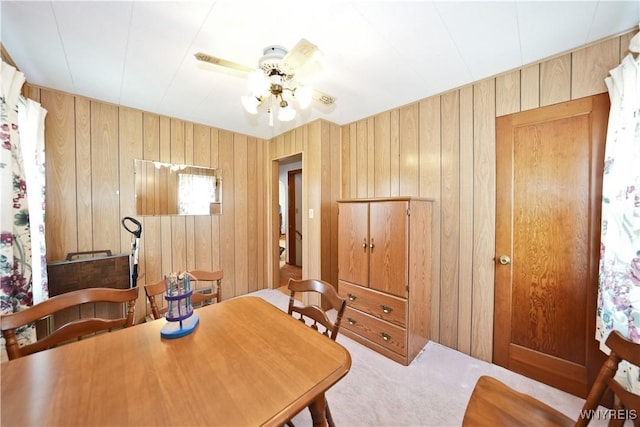 6167 N Whitham Dr, Niagara, NY 14304 - carpeted dining room with wood walls and a ceiling fan