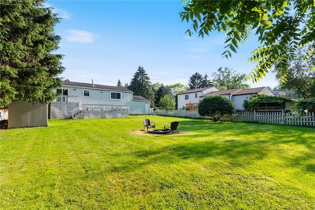 1535 Bluestem Ct, Walworth, NY 14568 - fenced backyard with a fire pit, a wooden deck, stairs, and a storage unit