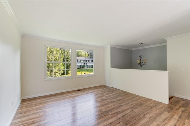 1535 Bluestem Ct, Walworth, NY 14568 - empty room with wood finished floors, ornamental molding, and a chandelier