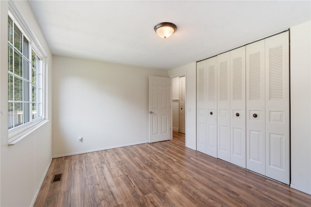 1535 Bluestem Ct, Walworth, NY 14568 - unfurnished bedroom featuring wood finished floors and a closet
