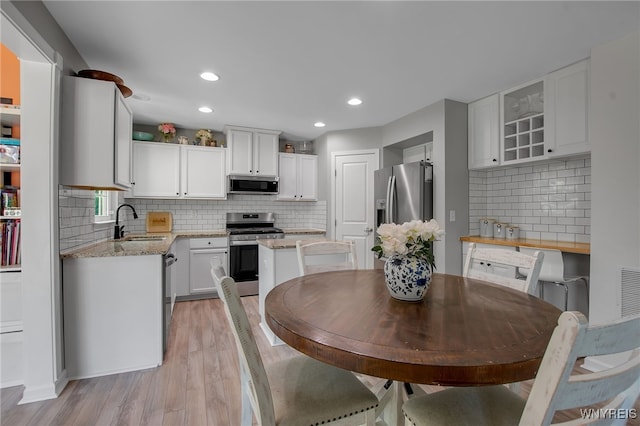 5 Scooter Ln, Hamburg, NY 14075 - kitchen featuring stainless steel appliances, decorative backsplash, light wood-type flooring, and recessed lighting