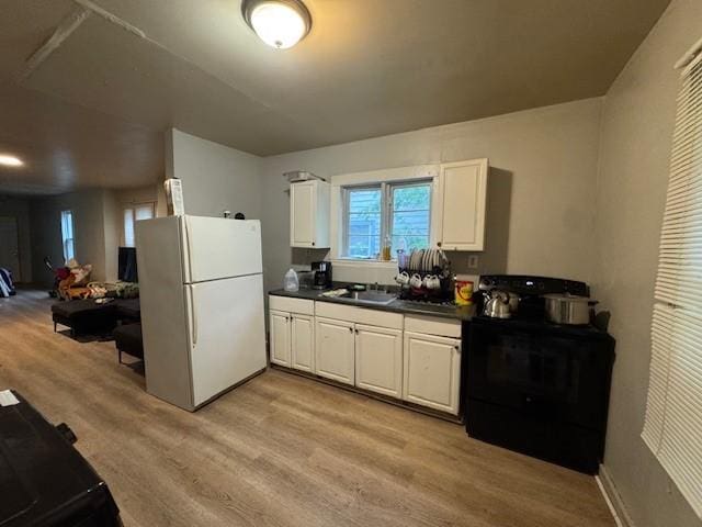 355 Champlain St Unit 353, Rochester, NY 14611 - kitchen featuring freestanding refrigerator, electric range, light wood-style floors, dark countertops, and white cabinetry