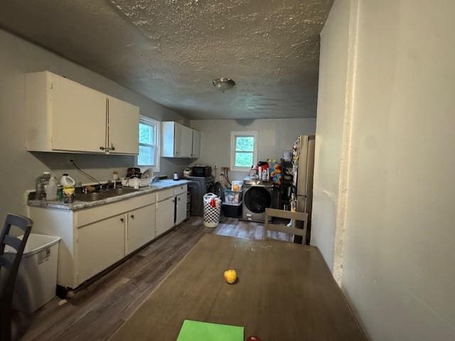 355 Champlain St Unit 353, Rochester, NY 14611 - kitchen featuring washer / dryer, dark wood-type flooring, white cabinetry, a textured ceiling, and light countertops