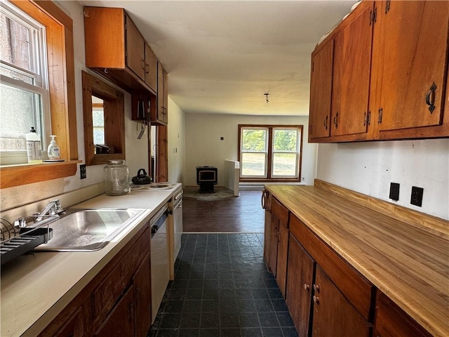 672 Backus Rd, New Lisbon, NY 13415 - kitchen featuring a wood stove, dishwasher, brown cabinetry, and open floor plan