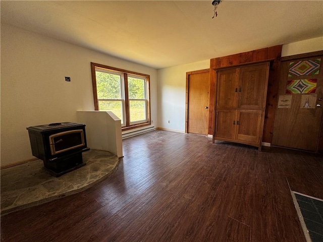 672 Backus Rd, New Lisbon, NY 13415 - unfurnished living room with a baseboard radiator, dark wood-style flooring, and a wood stove