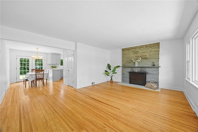 33 W Crest Dr, Gates, NY 14606 - living room with light wood-style flooring, a chandelier, and a large fireplace
