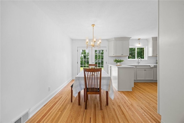 33 W Crest Dr, Gates, NY 14606 - dining room featuring a chandelier, light wood finished floors, and plenty of natural light