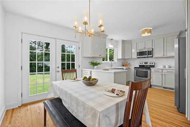 33 W Crest Dr, Gates, NY 14606 - dining space with light wood-style flooring, a chandelier, and french doors