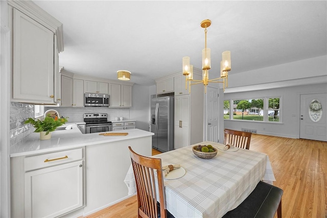 33 W Crest Dr, Gates, NY 14606 - dining room with a chandelier and light wood-style floors
