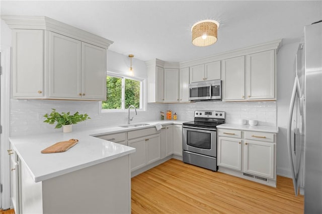 33 W Crest Dr, Gates, NY 14606 - kitchen featuring appliances with stainless steel finishes, a peninsula, and light wood-style floors