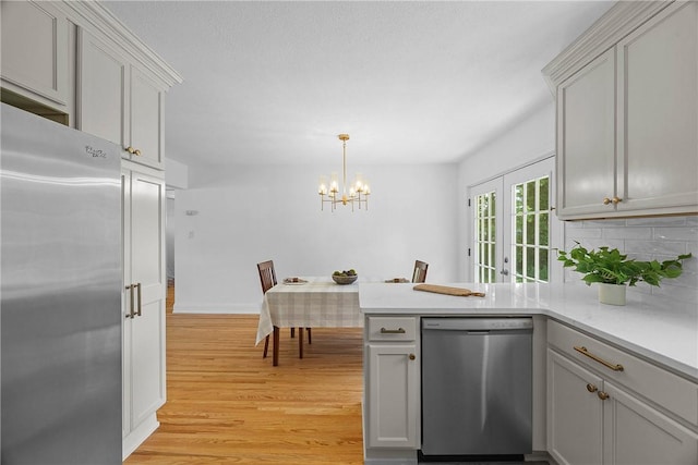 33 W Crest Dr, Gates, NY 14606 - kitchen featuring stainless steel appliances, a peninsula, light wood-style floors, light countertops, and tasteful backsplash