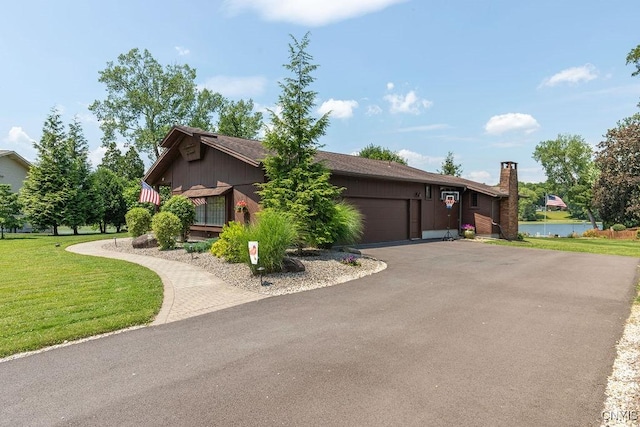 117 Shoreview Dr, Clay, NY 13090 - view of side of home featuring asphalt driveway, a garage, a yard, a chimney, and a water view