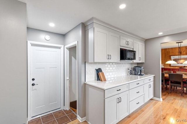 117 Shoreview Dr, Clay, NY 13090 - kitchen with black microwave, decorative backsplash, light countertops, white cabinetry, and recessed lighting