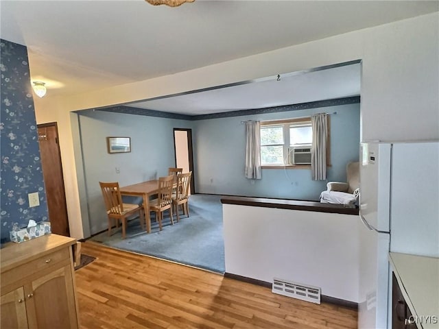 313 Chestnut St, Oswego, NY 13126 - dining area with light wood-style floors, wallpapered walls, and cooling unit