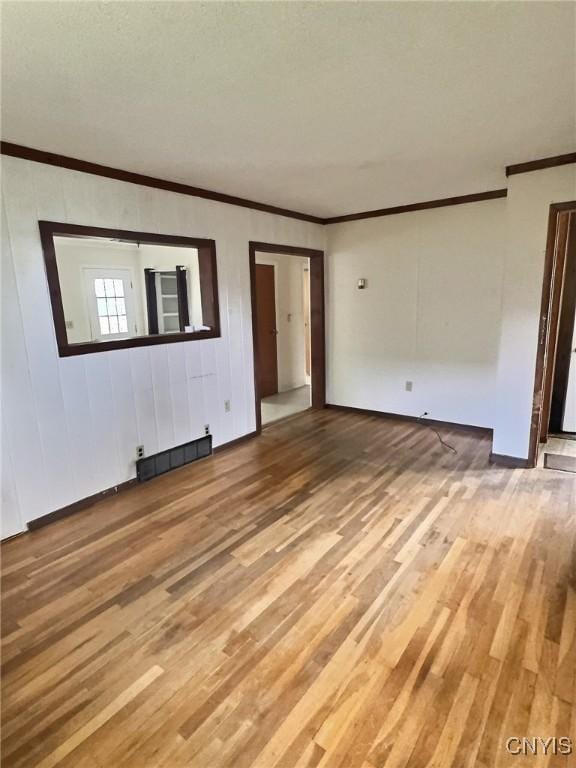 313 Chestnut St, Oswego, NY 13126 - unfurnished living room with ornamental molding and light wood finished floors