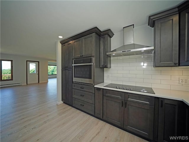 213 Bradshaw Rd, Dryden, NY 13053 - kitchen with stainless steel oven, wall chimney exhaust hood, a baseboard heating unit, black electric stovetop, and light wood-style floors