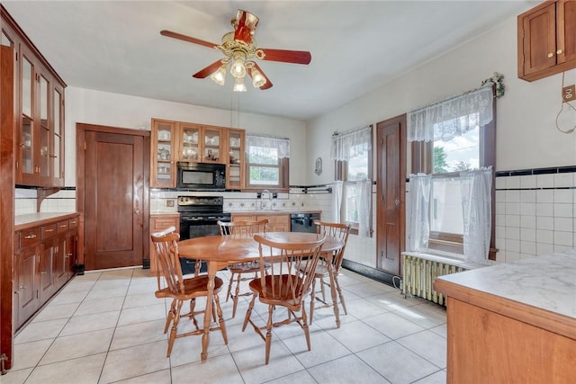 112 Isabelle St, Rochester, NY 14606 - dining area with a ceiling fan, light tile patterned floors, and radiator