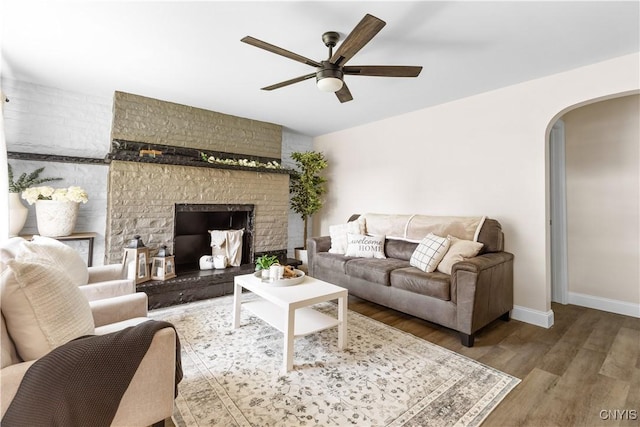 161 Forrest St, Deerfield, NY 13502 - living area featuring arched walkways, ceiling fan, wood finished floors, and a fireplace