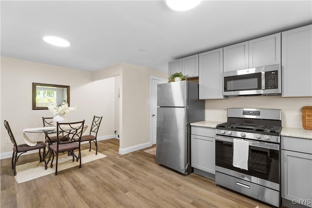 161 Forrest St, Deerfield, NY 13502 - kitchen with stainless steel appliances, light countertops, light wood-style floors, and gray cabinets