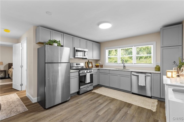 161 Forrest St, Deerfield, NY 13502 - kitchen with stainless steel appliances, gray cabinetry, light wood-style floors, and light countertops