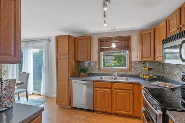 3675 Buttercup Ln, Clay, NY 13027 - kitchen featuring stainless steel appliances, dark countertops, light wood-style flooring, and backsplash