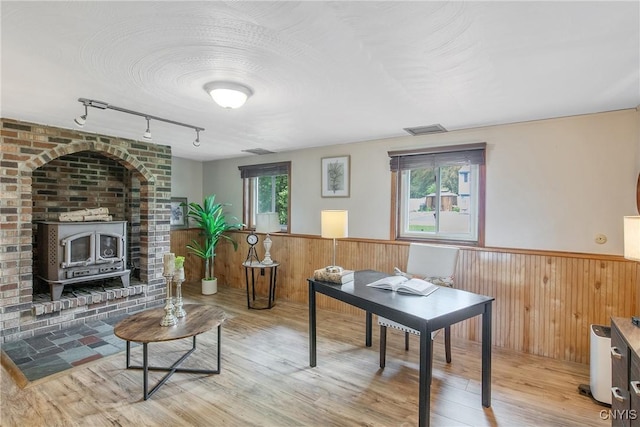 3675 Buttercup Ln, Clay, NY 13027 - living room featuring wainscoting, wood finished floors, a wood stove, wood walls, and rail lighting