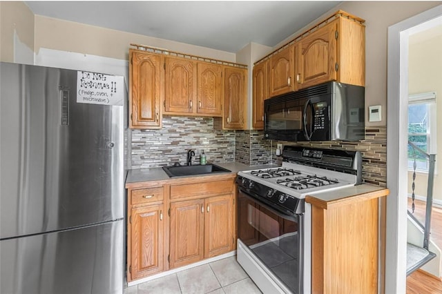 1162 Draper Ave, Elmira, NY 14905 - kitchen featuring freestanding refrigerator, black microwave, gas range oven, backsplash, and light countertops